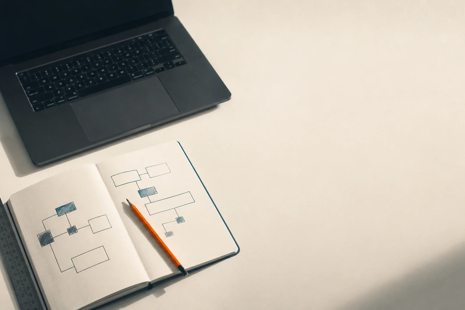 Un carnet ouvert sur un schéma de modules, posé sur un établi