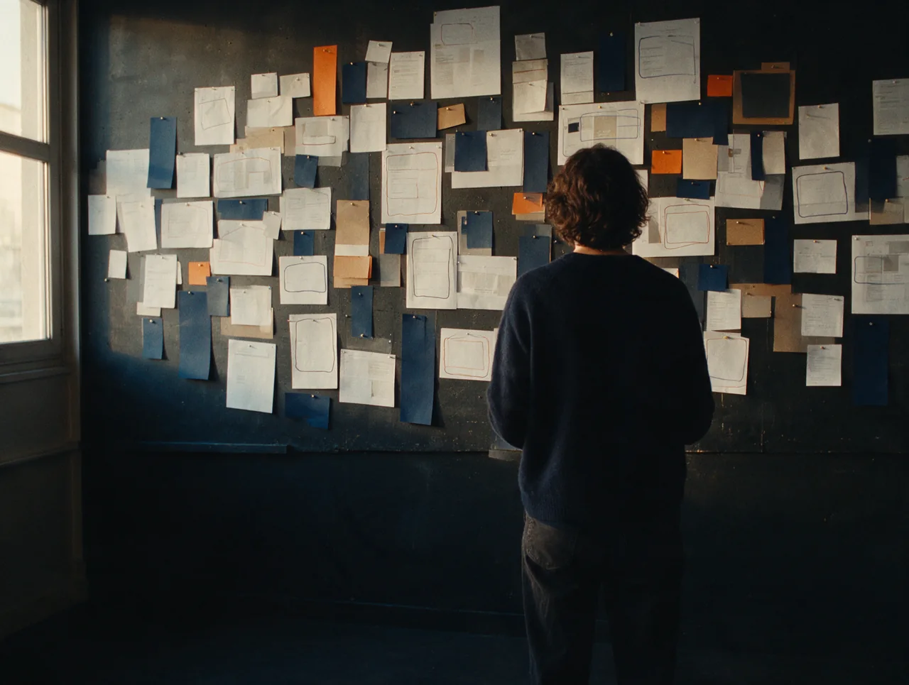 Un mur de notes punaisées observé en retrait